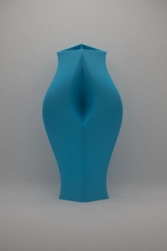 Pink sculptural vase on a shelf against a grey wall