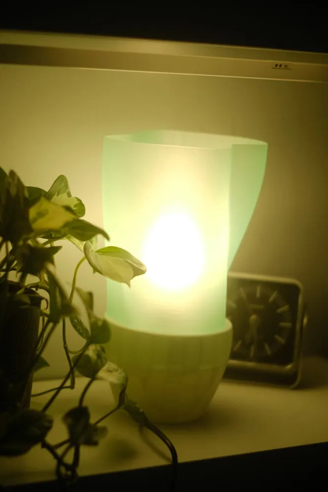 Close-up of the Flowing E14 Lamp's flowing white shade and green base