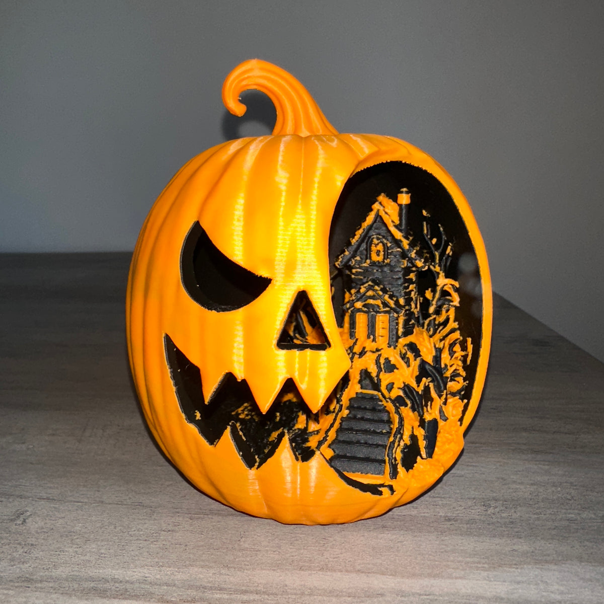 Haunted Jack-o'-Lantern Diorama — front view showing carved face and haunted house scene