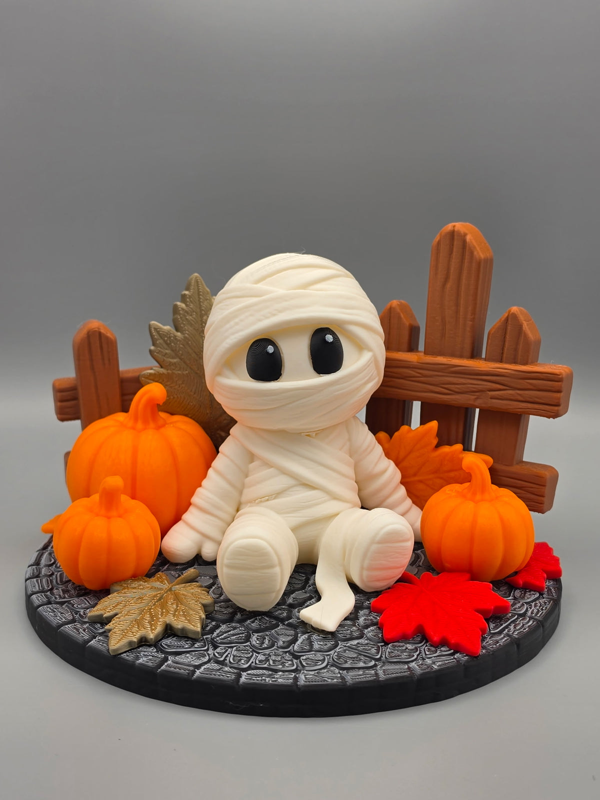 Halloween Mummy Sitting Figure — front-on close view showing expressive black eyes and layered bandage wrapping detail