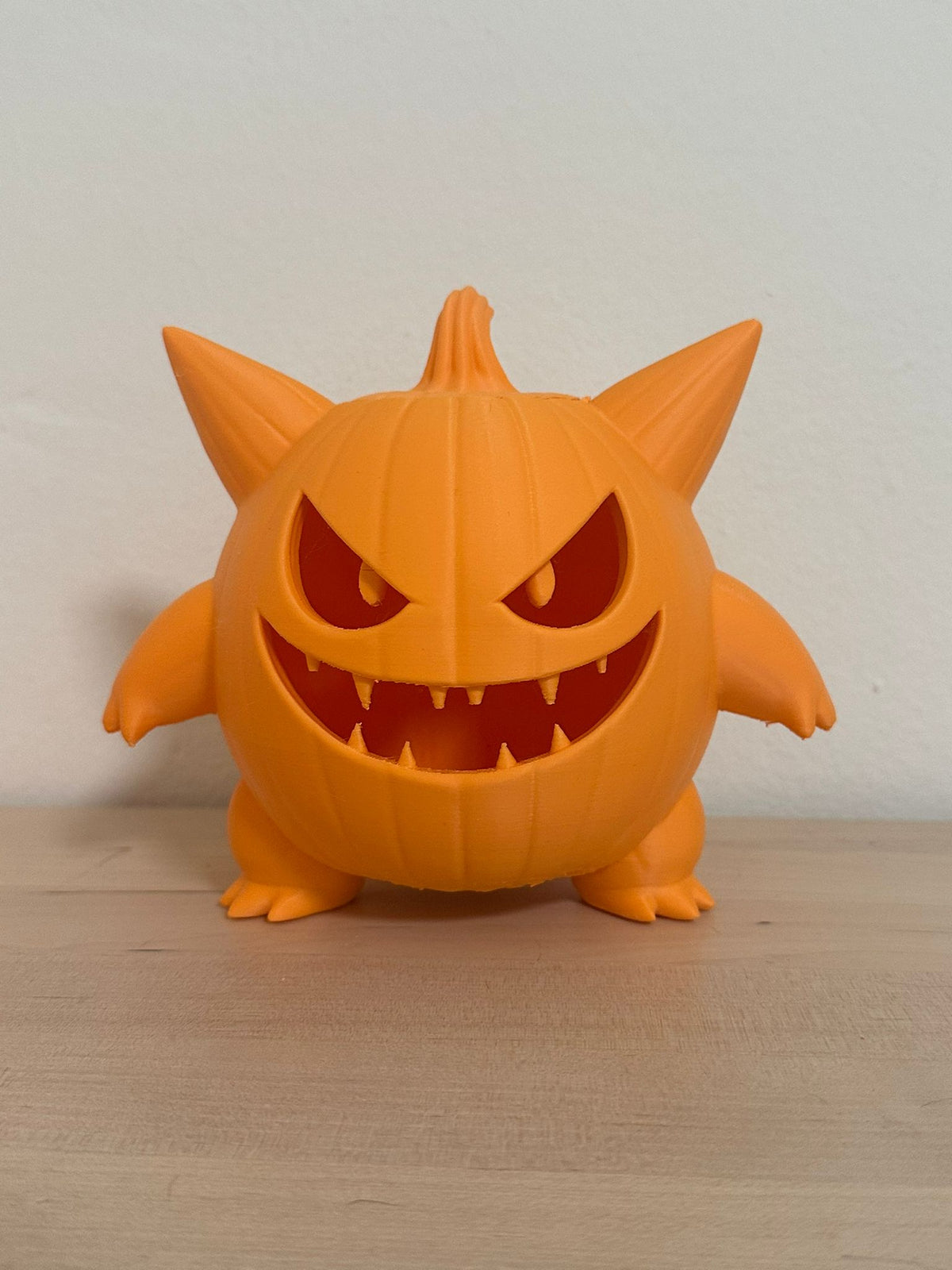 Monster Pumpkin Tealight Holder — front glow shot showing full amber tealight effect through carved face against deep orange background
