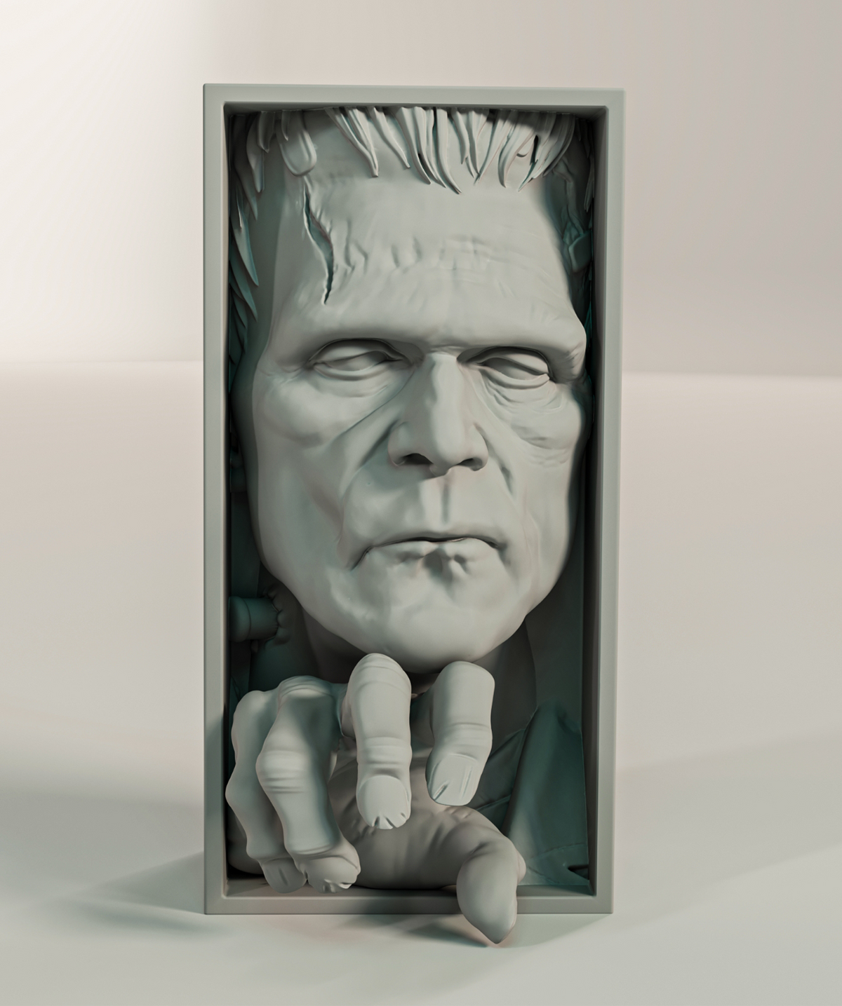 Frankenstein monster relief sculpture grey matte rectangular framed box deeply modelled face heavy brow bolt neck hair grasping clawed hand reaching forward front facing view neutral background hero product shot