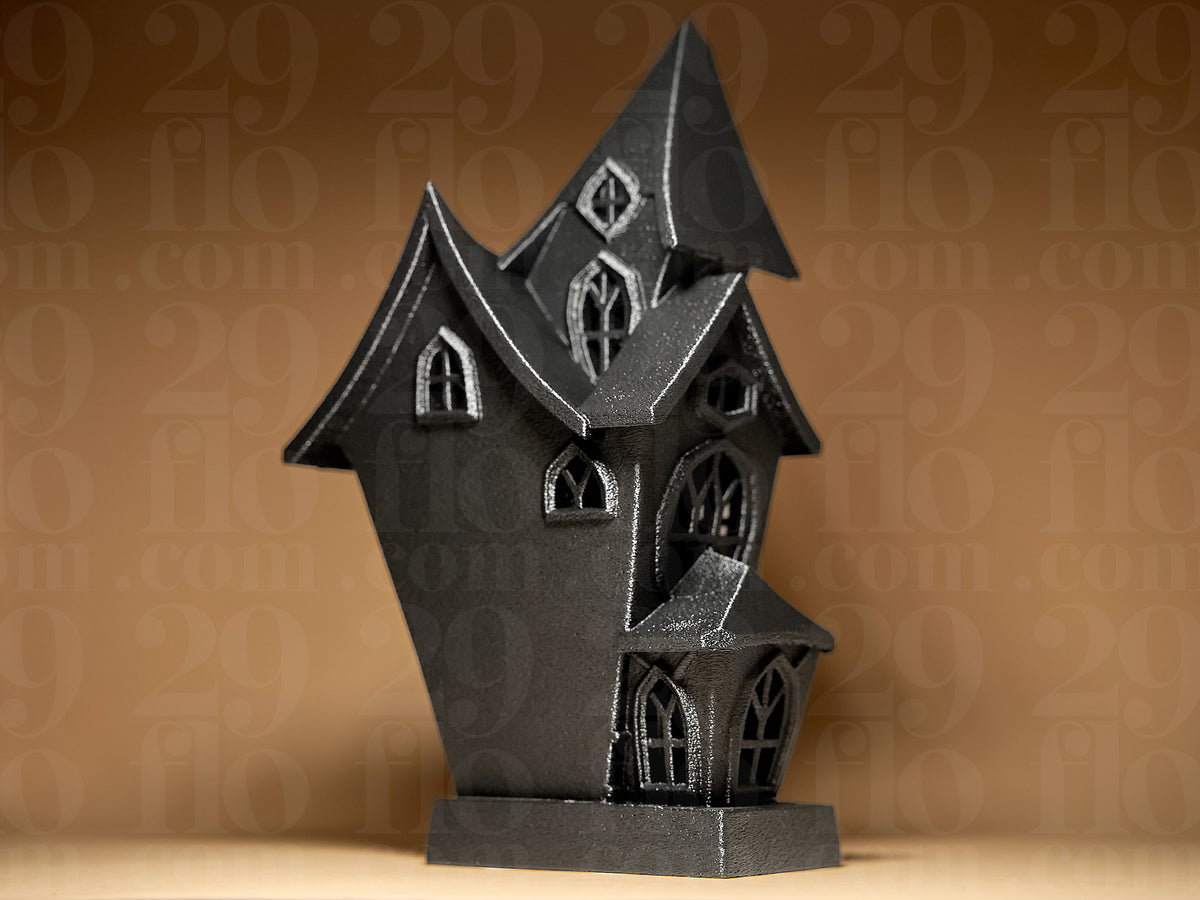 Haunted House Tealight Holder in Black — unlit side view showing peaked rooflines, gothic window frames and textured exterior detail