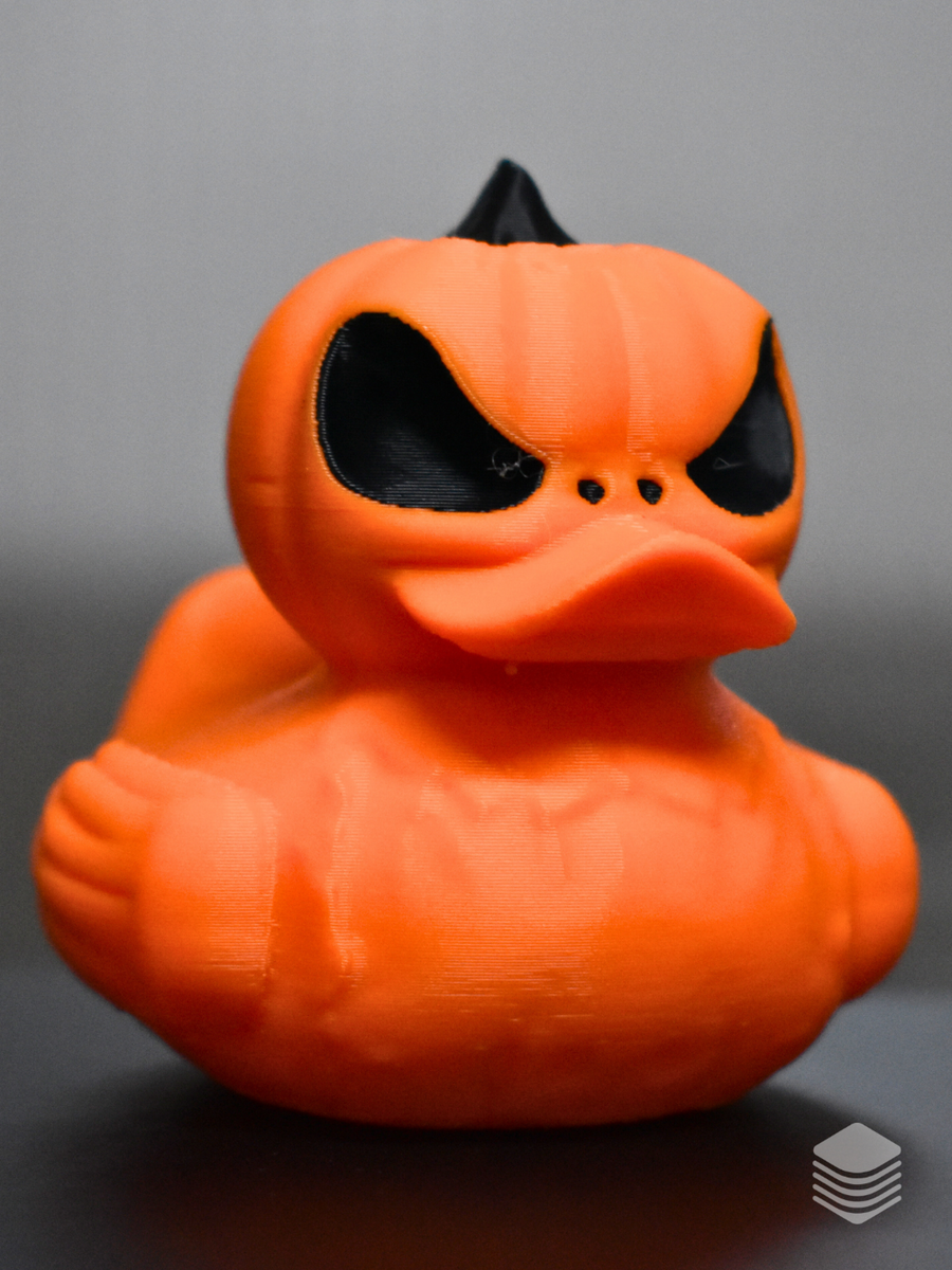 Halloween Pumpkin Duck — close-up angry face: vivid orange pumpkin head with vertical lobe lines, two large angled black void eye apertures, heavy angular furrowed brow ridges, three black circular nostril punches, orange duck bill integrated into carved face, black pointed stem at crown