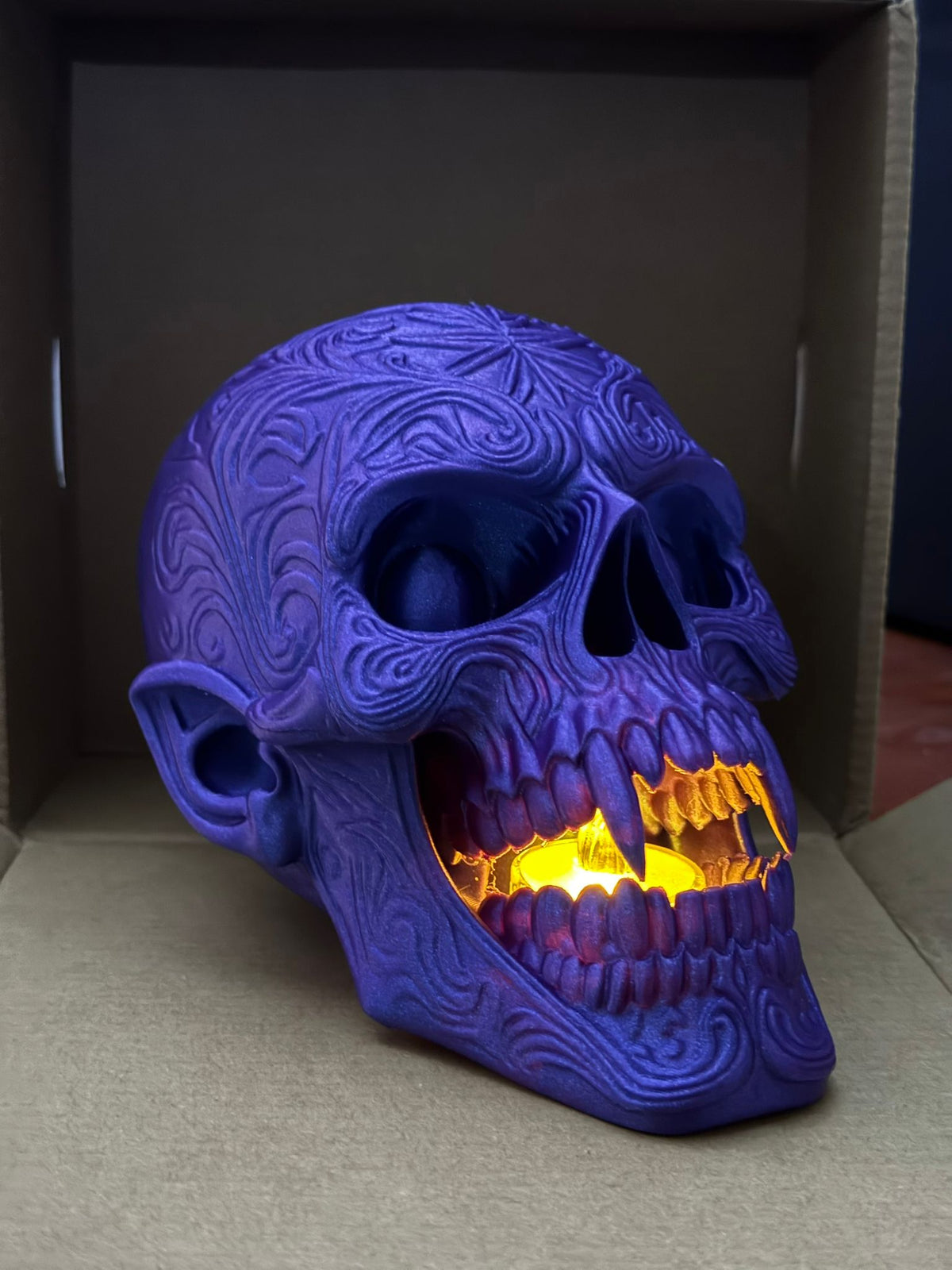 Skull Tealight Holder in purple — three-quarter angle showing cranium filigree and glowing jaw