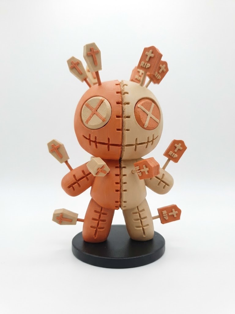 Voodoo Pin Cushion Doll Figure — Plain base edition front view showing two-tone terracotta and beige body with cross X eyes and stitched seam detail without themed pin toppers on black stand