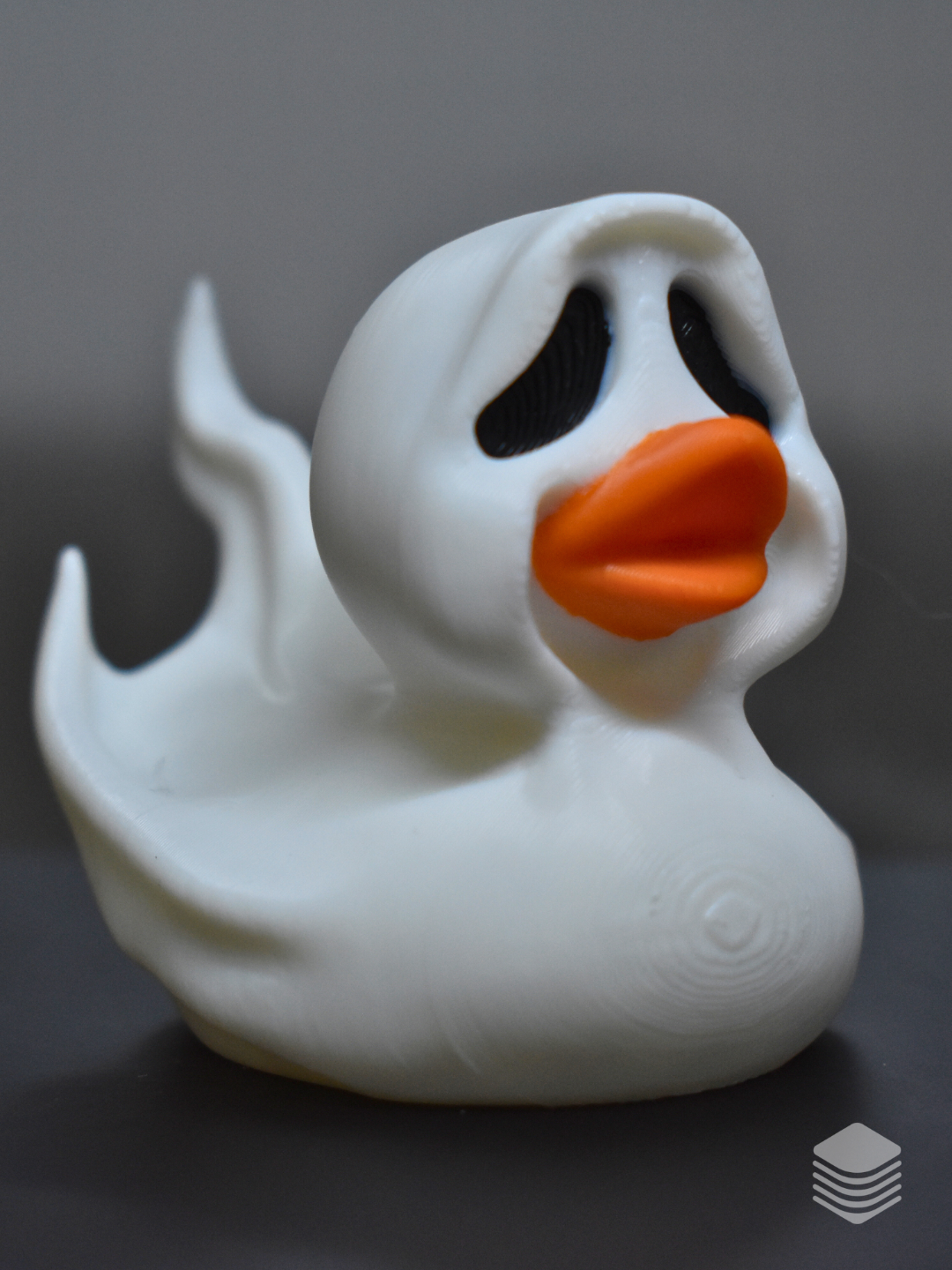 Halloween Ghost Duck Sculpture — close-up face view: pure white ghost sheet with rounded peak hood, two large black teardrop void eye apertures deeply recessed, vivid orange duck bill protruding from ghost sheet at face centre, soft white matte surface with natural drape folds at hood sides
