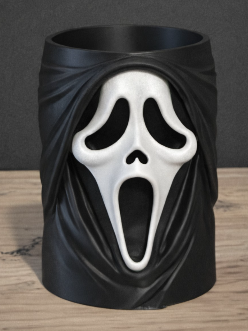 Ghostface Scream Can & Pen Holder in matte black with white Ghostface screaming mask — front view showing full draped robe sculpture and mask detail on wooden surface against grey background