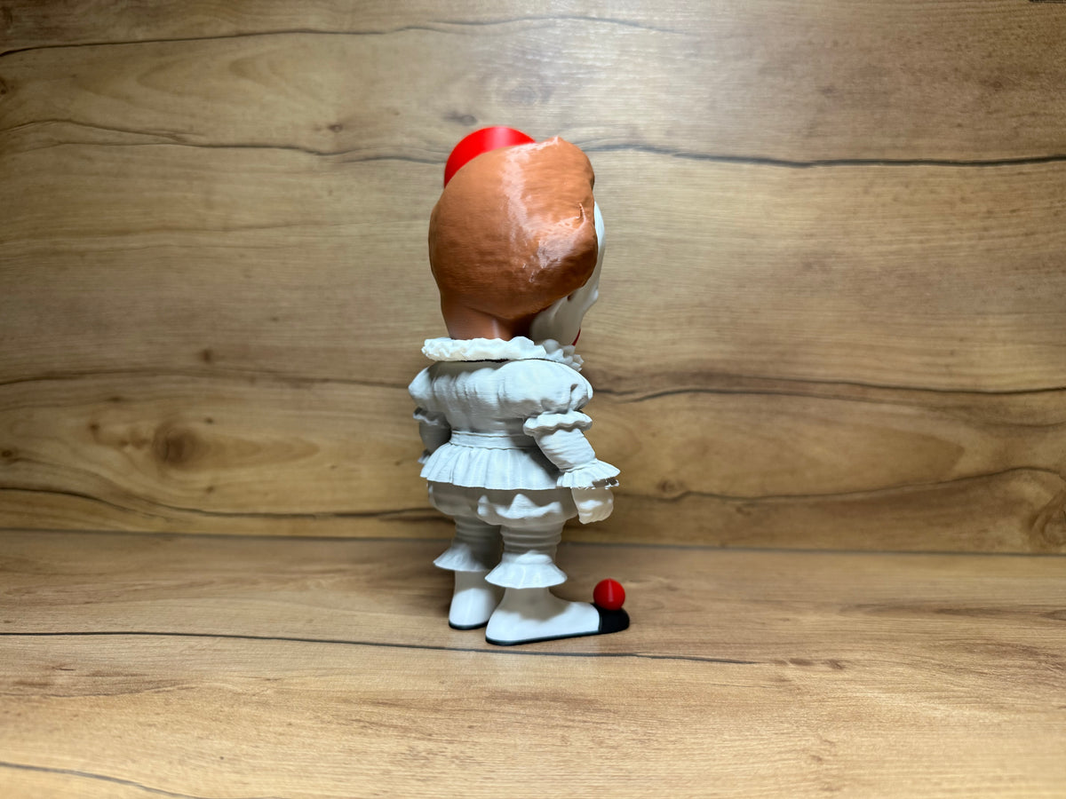 Pennywise IT Horror Minifigure Sculpture — rear view showing bald crown dome with auburn hair tufts on both sides from behind, red balloon visible at head height on right, white clown suit rear with ruffled waist skirt tier, white puffed legs from rear and black shoes with red pompom at toe visible from rear angle