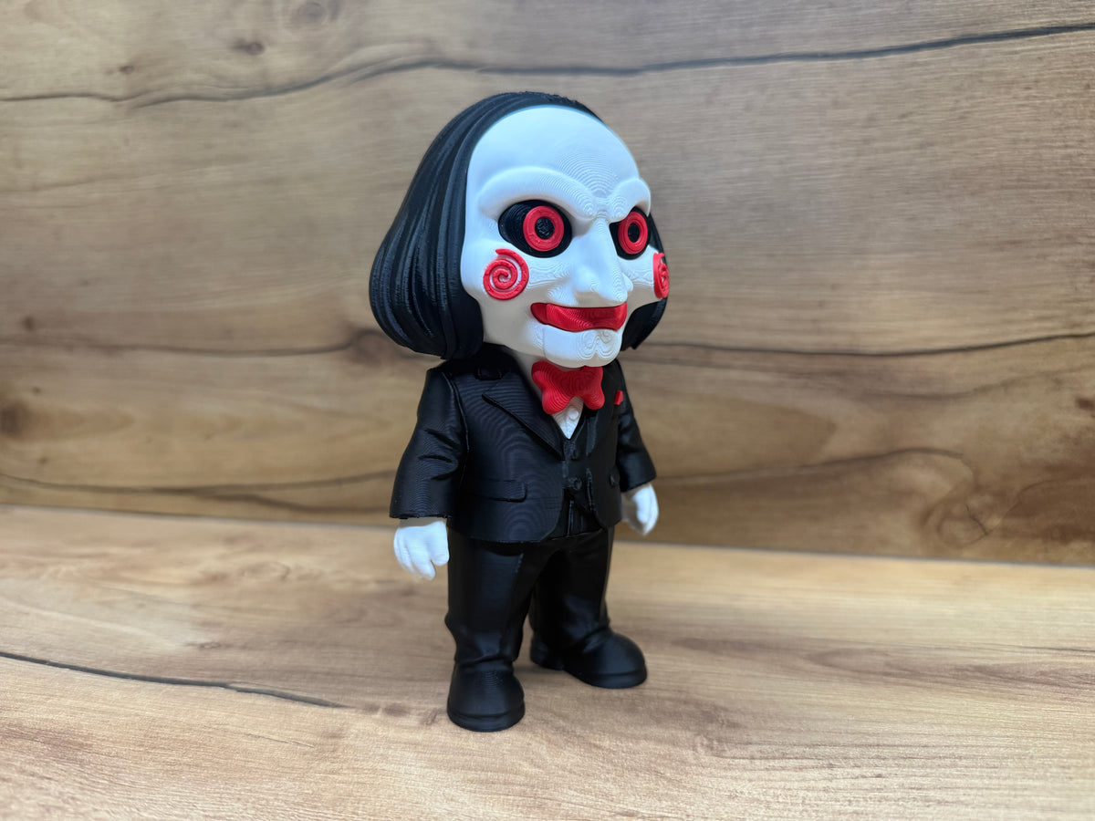Billy the Puppet Saw Minifigure Sculpture — rear three-quarter view showing full black bob hair strand texture from centre parting, black suit jacket back panel, trouser legs and black shoes with white glove hands at sides