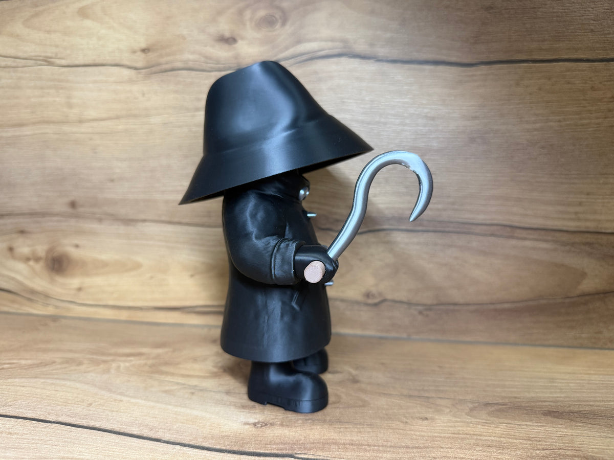 Candyman Horror Minifigure Sculpture — right side profile view showing wide hat brim sweep and deep crown, concealed face shadow zone with single silver goggle eye visible, full length textured black coat profile, right arm extended forward holding silver hook blade