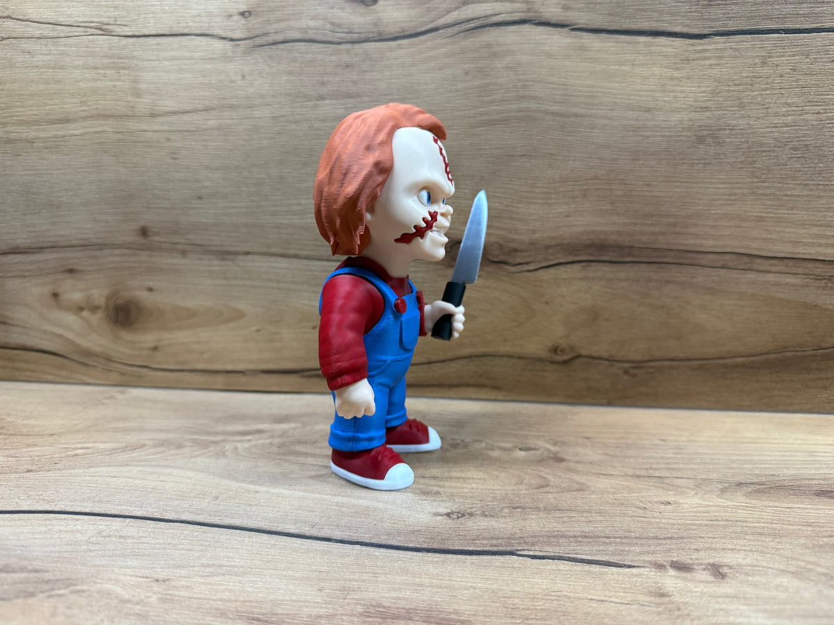 Chucky Child's Play Horror Minifigure — right side profile: orange-red hair, blue eye and scar visible, blue dungarees, right arm extended holding silver serrated knife with black handle, dark red trainer profile with white sole