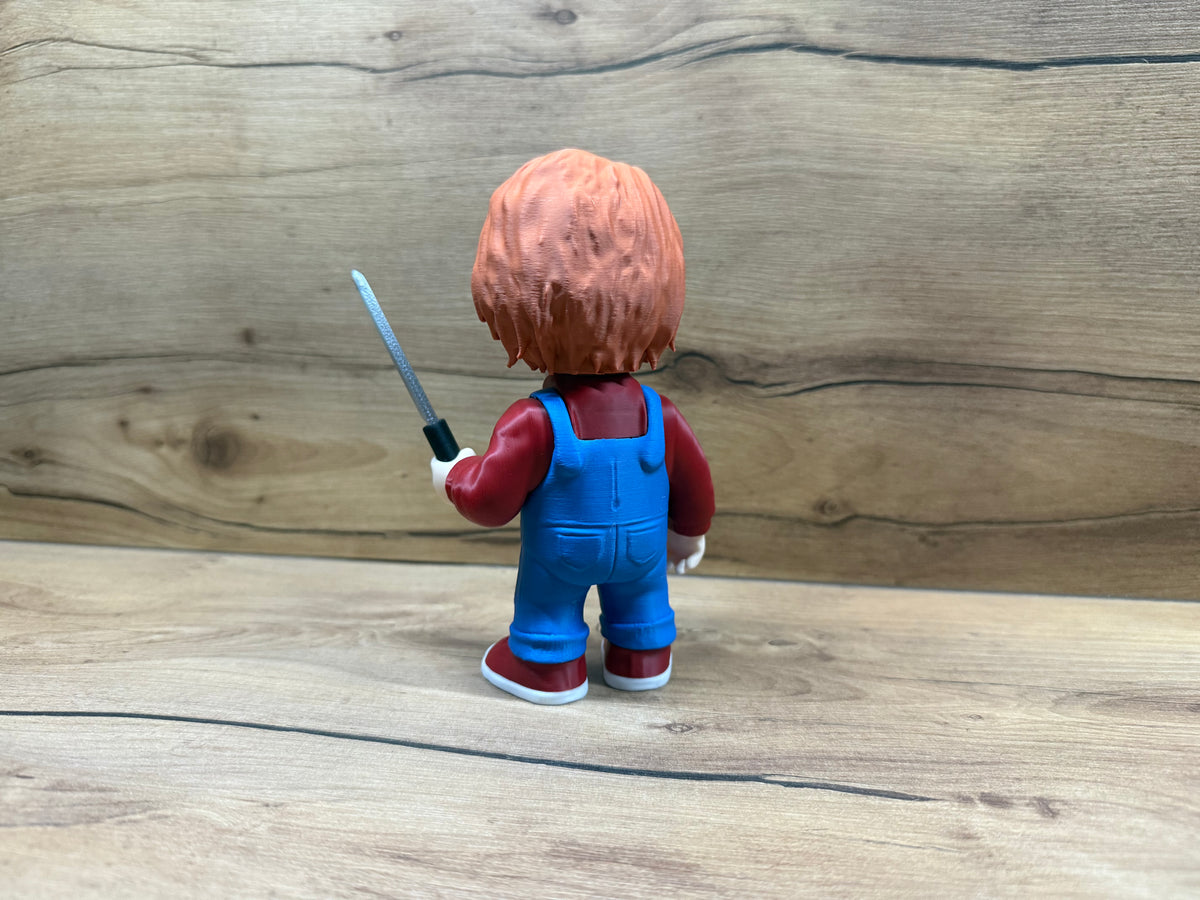 Chucky Child's Play Horror Minifigure — rear view: full orange-red hair mass with strand texture, blue dungaree rear panel with back patch pocket, dungaree strap crossing, silver knife visible at right side, dark red trainers with white soles from rear