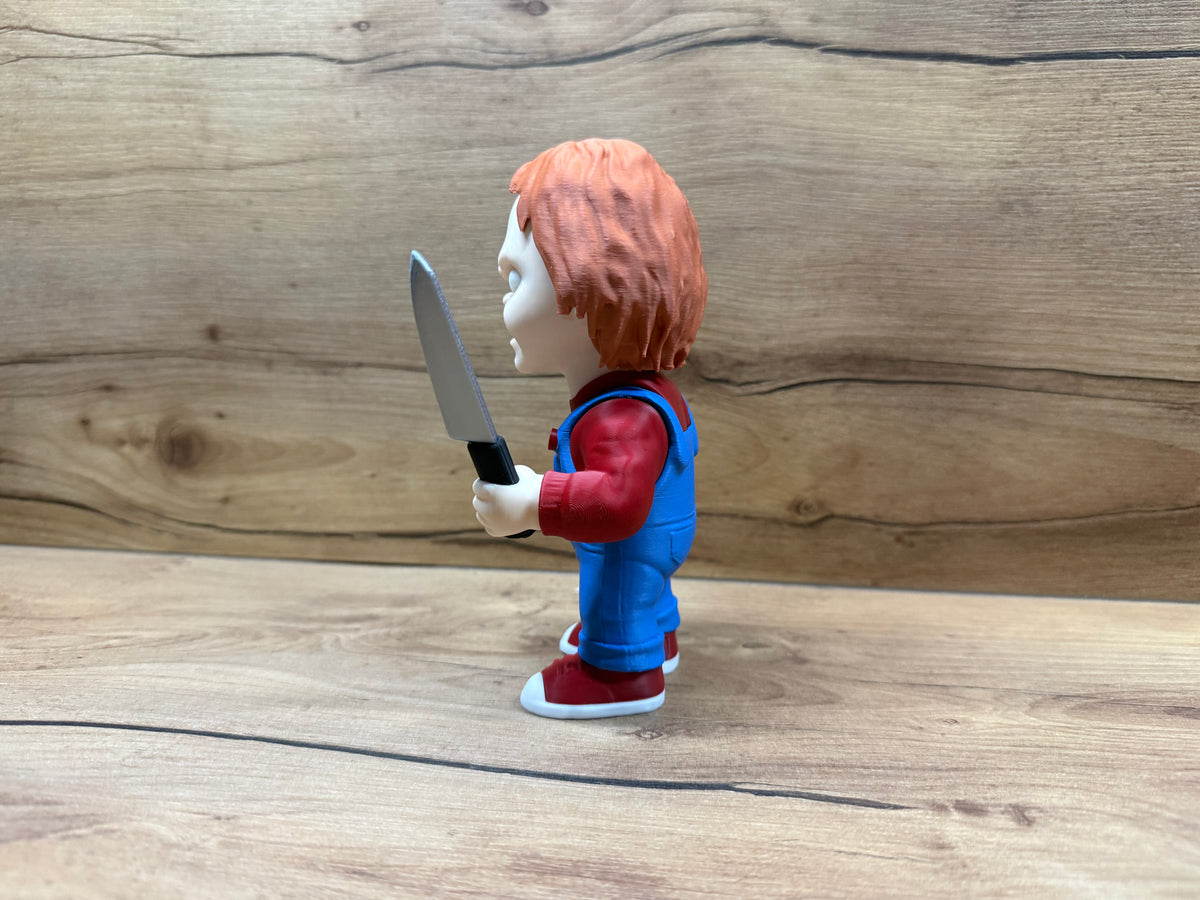 Chucky Child's Play Horror Minifigure — left side profile: red zigzag scar with suture stitches most prominent from left angle, vivid blue eye, orange-red hair, blue dungarees, silver serrated knife at chest height, dark red trainer with white sole