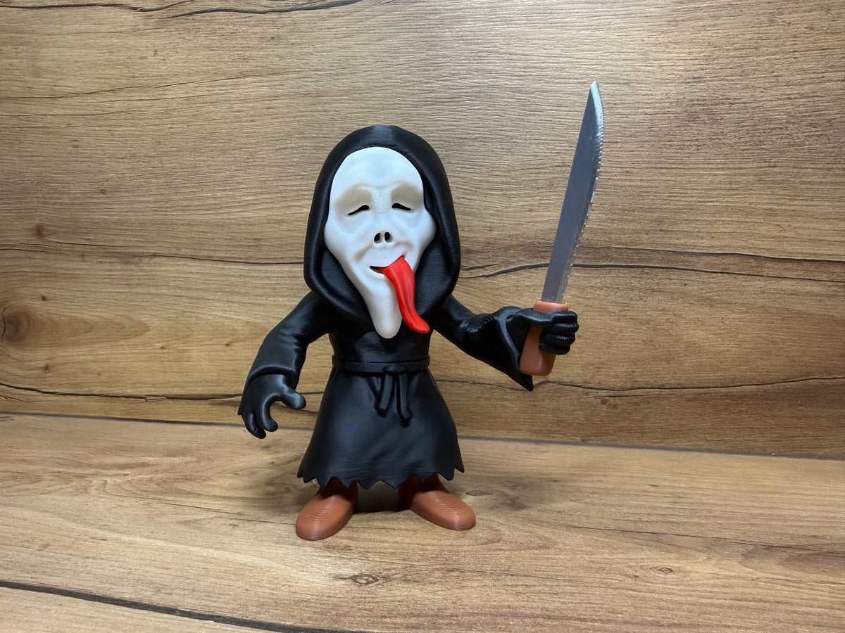Ghostface Scream Horror Minifigure Sculpture — front view tongue-out variant: identical figure to classic screaming mask variant with vivid red sculpted tongue extending and curling downward from open mouth aperture, two black teardrop eye apertures, black hooded robe with waist cord, right hand raised with silver serrated knife and brown handle, zigzag robe hem