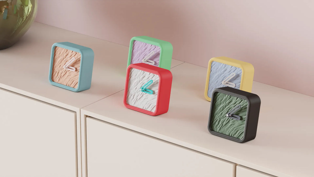 Modern Minimalist Textured Desk Clock Black frame with Green ripple texture face on travertine stone slabs beside glass vase greenery neutral background