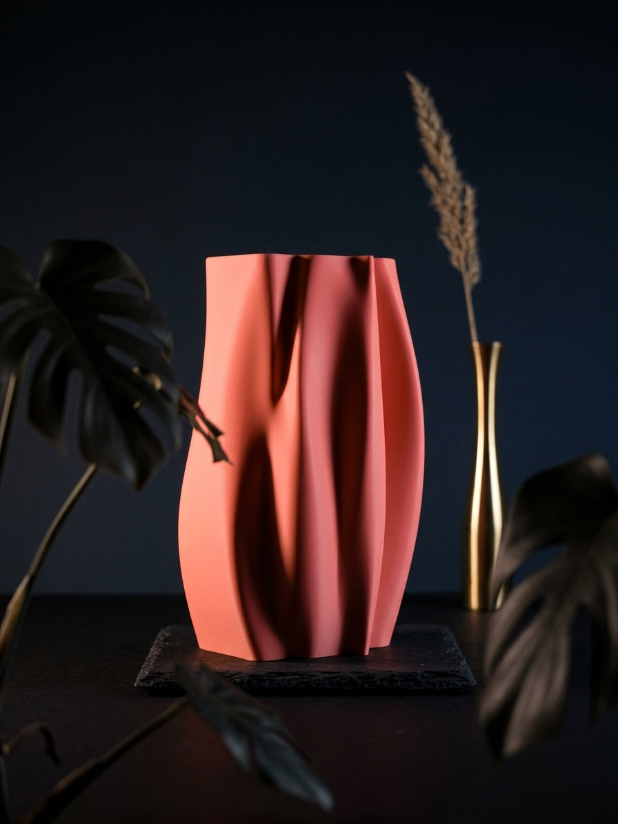 Elegant Organic Flow Vase pink on dark wooden surface against navy blue wall warm lamp light