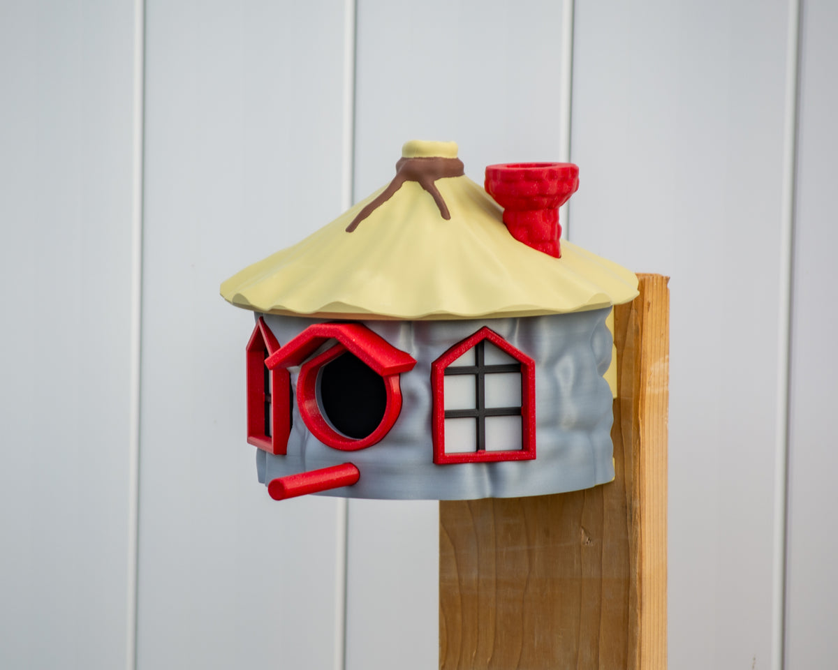 Cottage birdhouse mounted on a wooden post