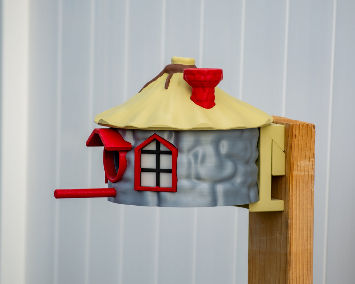 Side view of colourful birdhouse mounted to post
