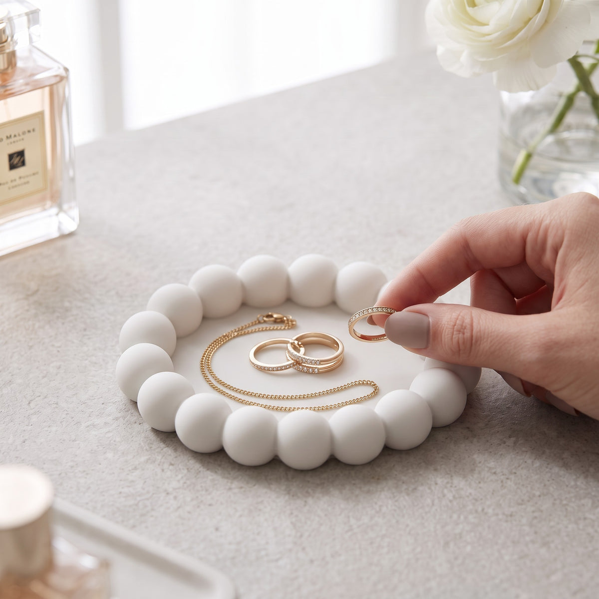 White round bubble tray with earrings and rings on a wooden dresser
