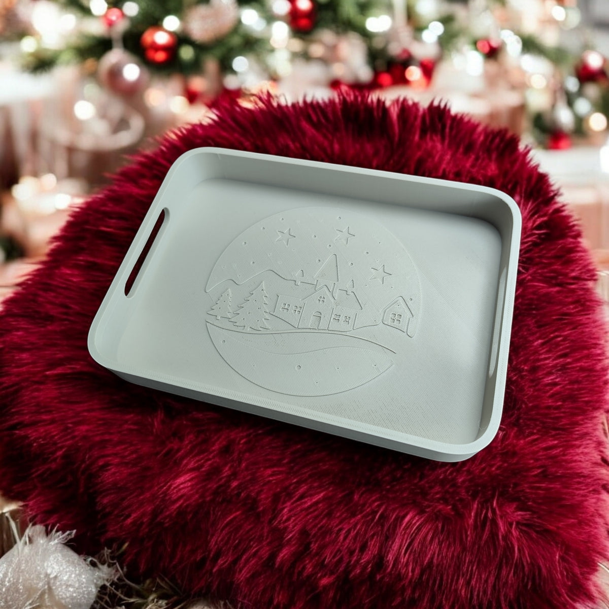 Winter village tray on dark wooden table surrounded by fairy lights pine sprigs and mini Christmas tree