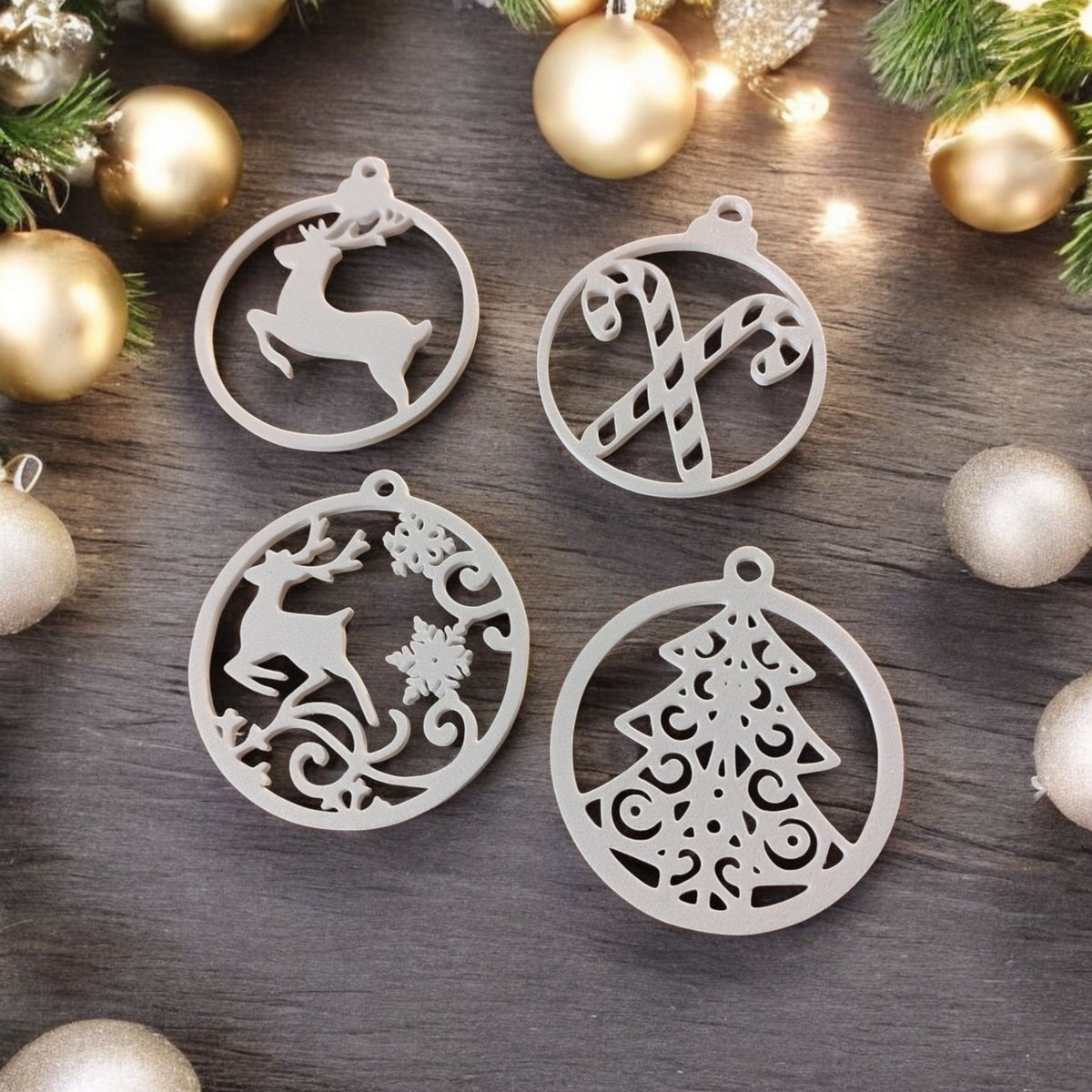10 piece Christmas tree ornament hanger set white plastic filigree cut-out baubles arranged in Christmas tree pyramid shape on deep red background all 10 designs visible snowflake reindeer Christmas tree candy cane bells star Santa hat deer stag filigree overhead flat lay hero shot