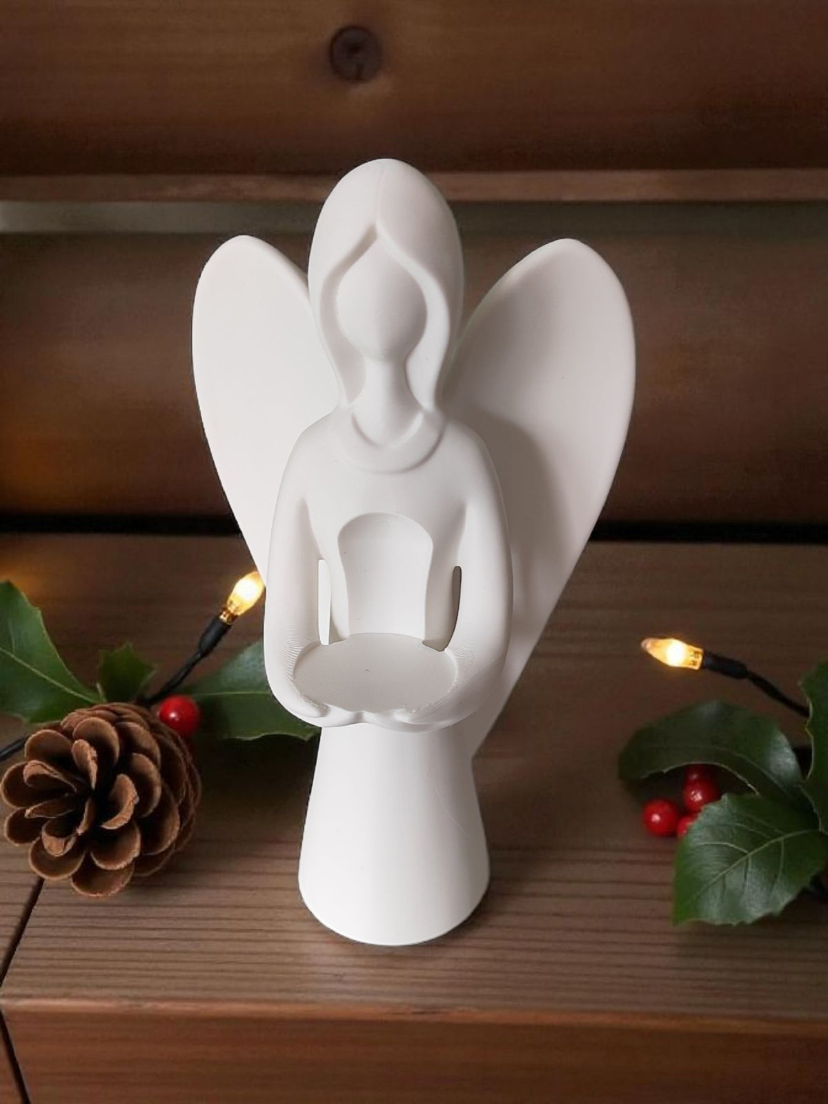 Back view of white angel sculpture on wooden plank table neutral background