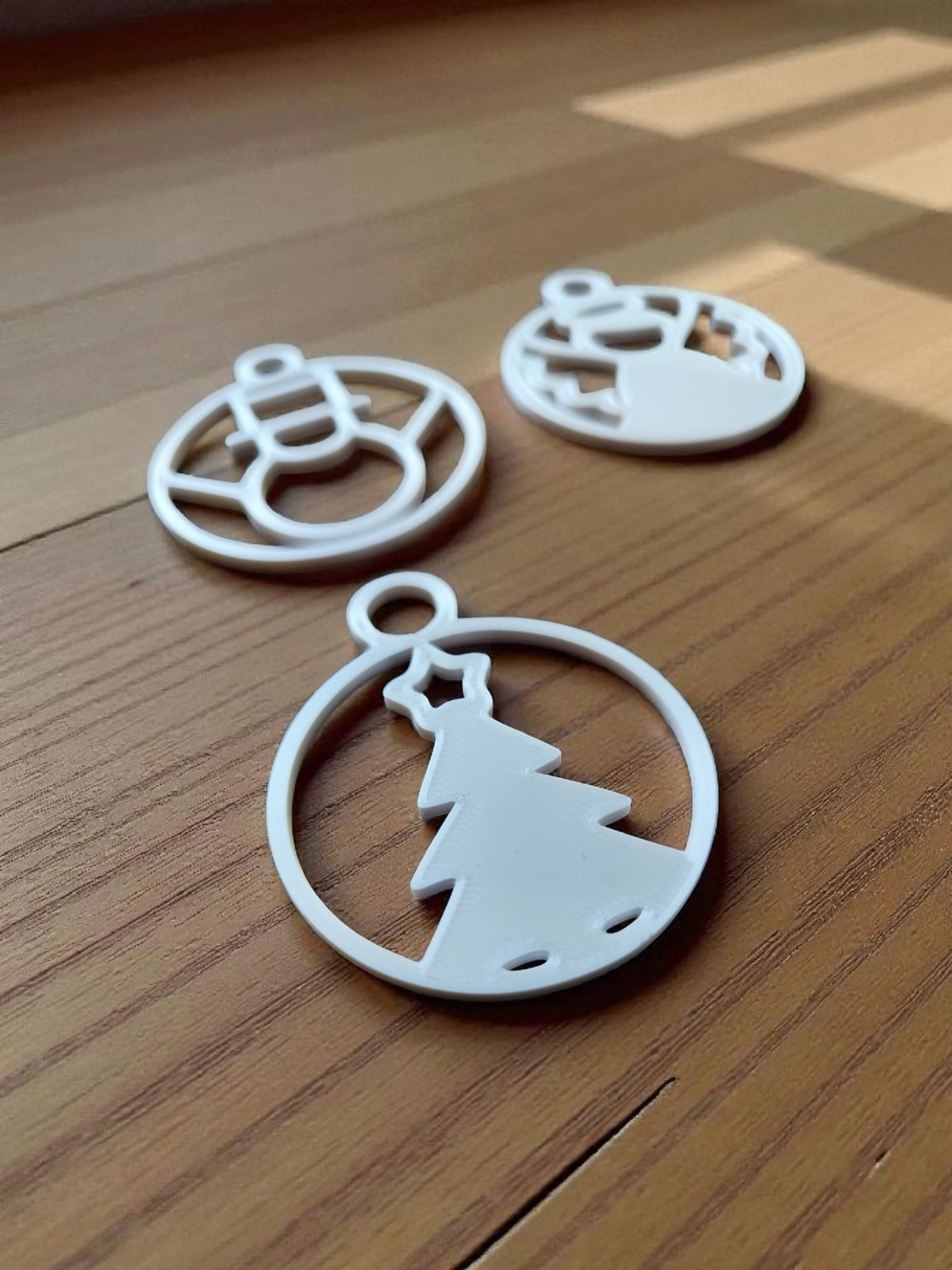 Gold robot and grey snowman minimalist Christmas ornaments flat lay on wood