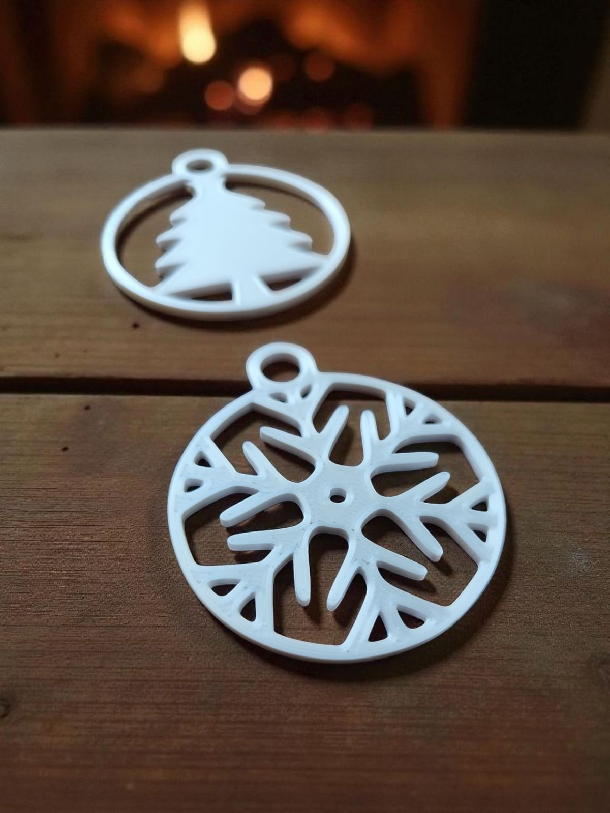Full set of eight Christmas ornaments styled with pine branches and red baubles on dark wood
