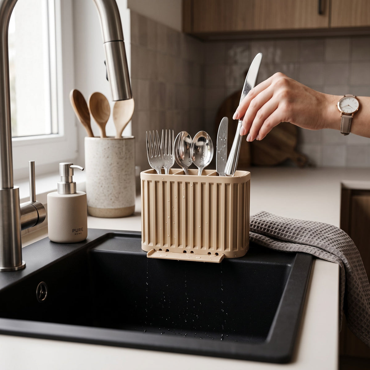 Japandi Cutlery Drainer beige beside chrome tap woman hand placing spoon lifestyle