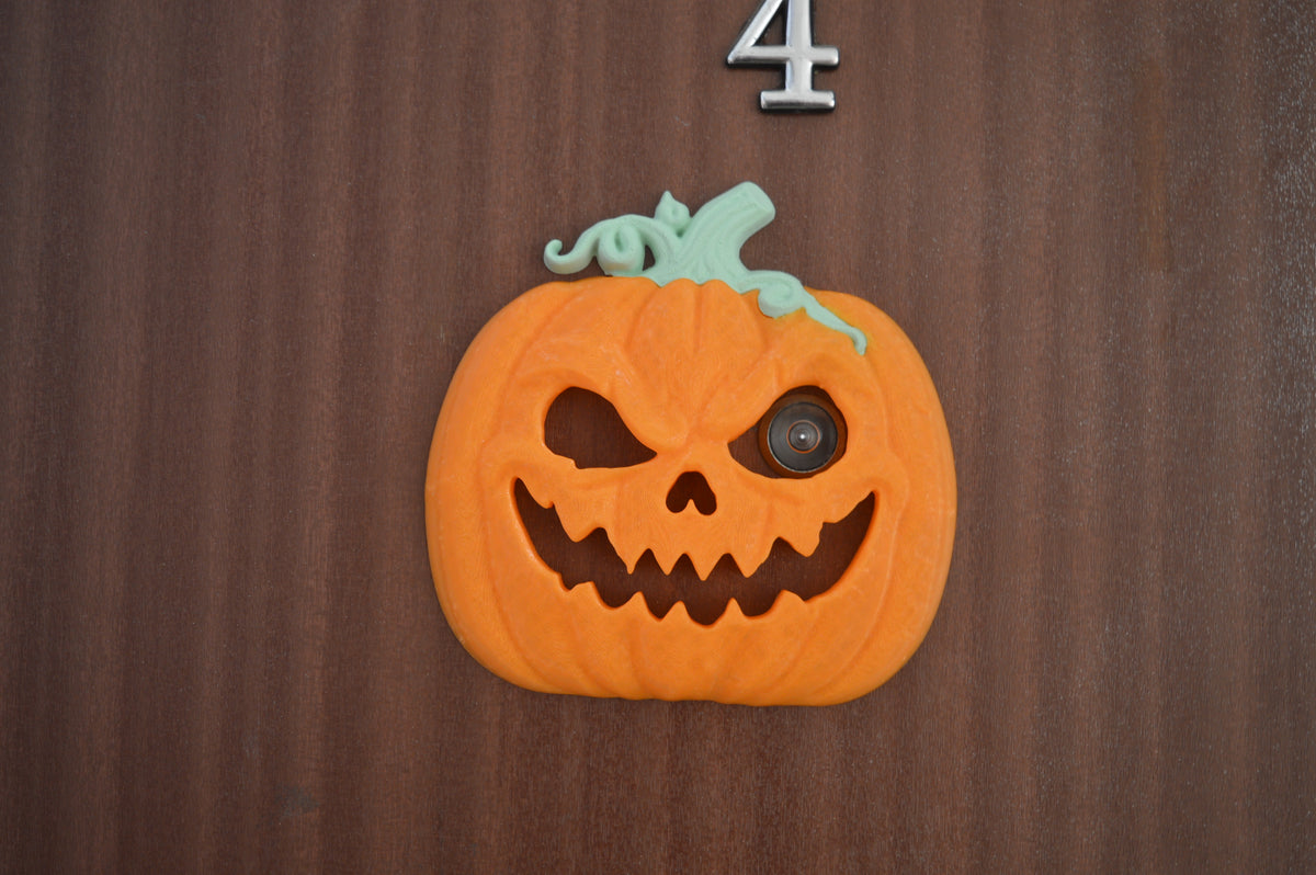 Pumpkin peep-hole decoration on dark front door
