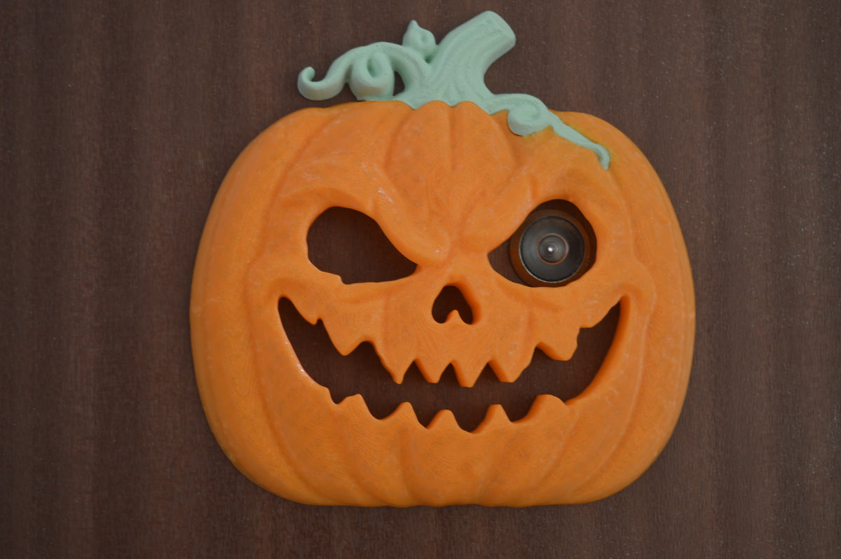 Hand beside pumpkin peep-hole decoration for scale