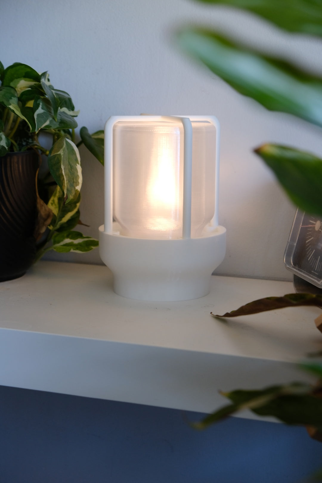 The Miner's Lantern Lamp real photo white close up front view warm amber glow through frosted cylinder and cage posts