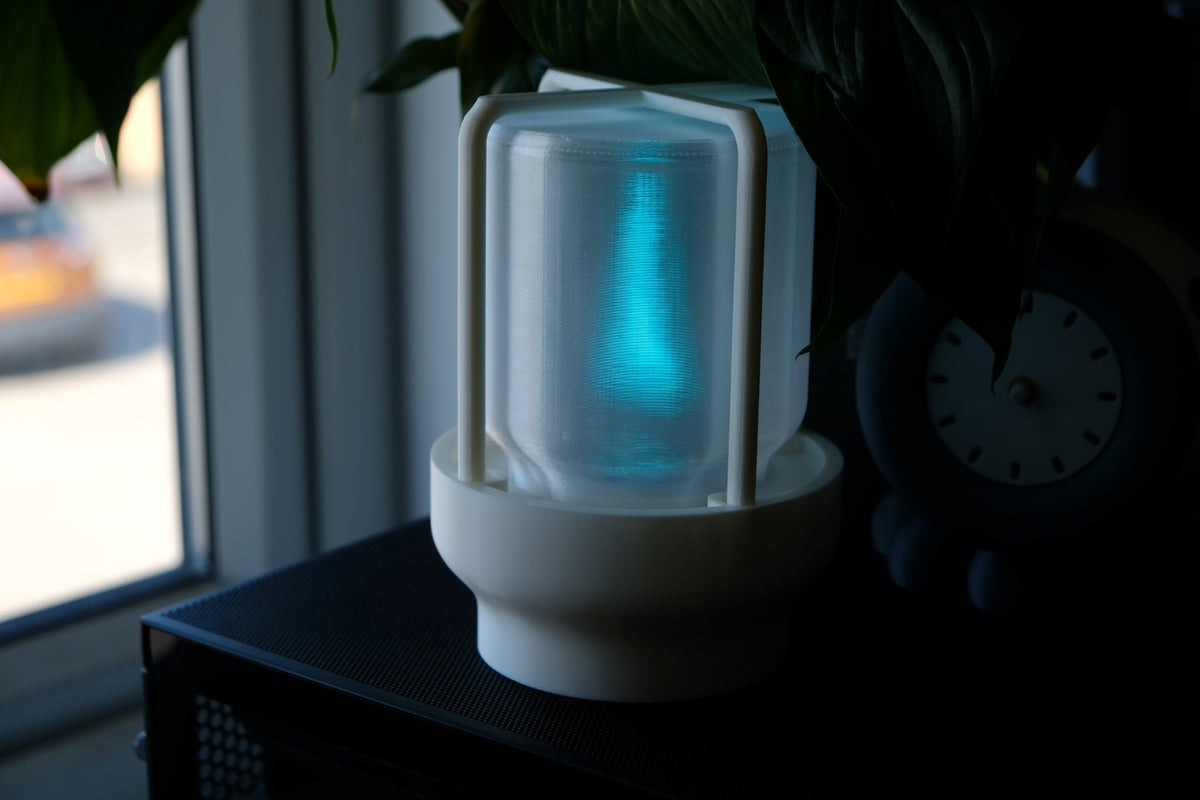 The Miner's Lantern Lamp real photo white glowing vivid neon cyan through frosted cylinder dark moody background dramatic