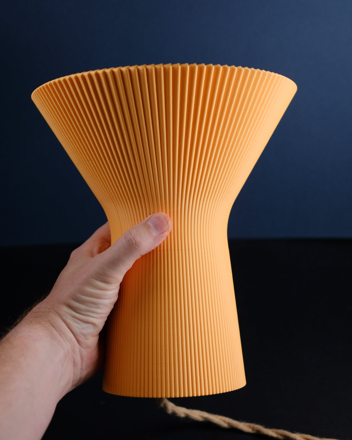 Angled close-up of the lamp's flared top and pleated surface.