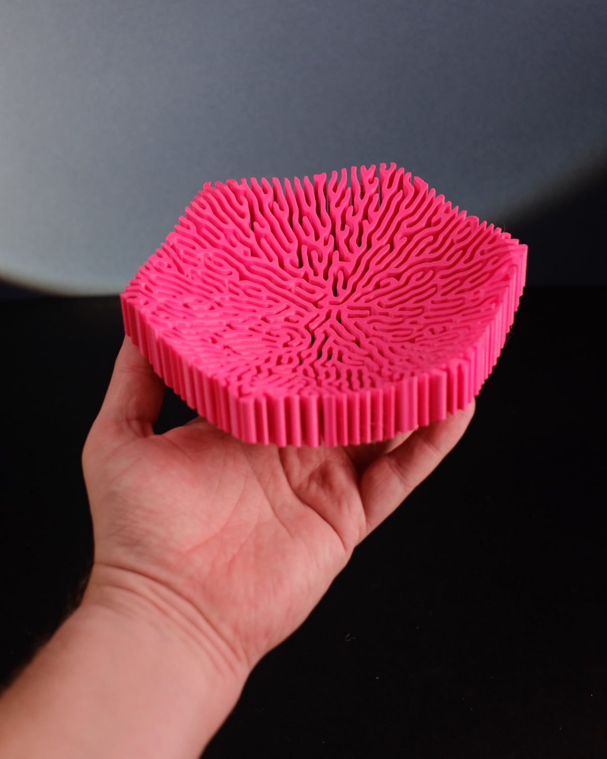 Pink coral storage bowl on dark wood console