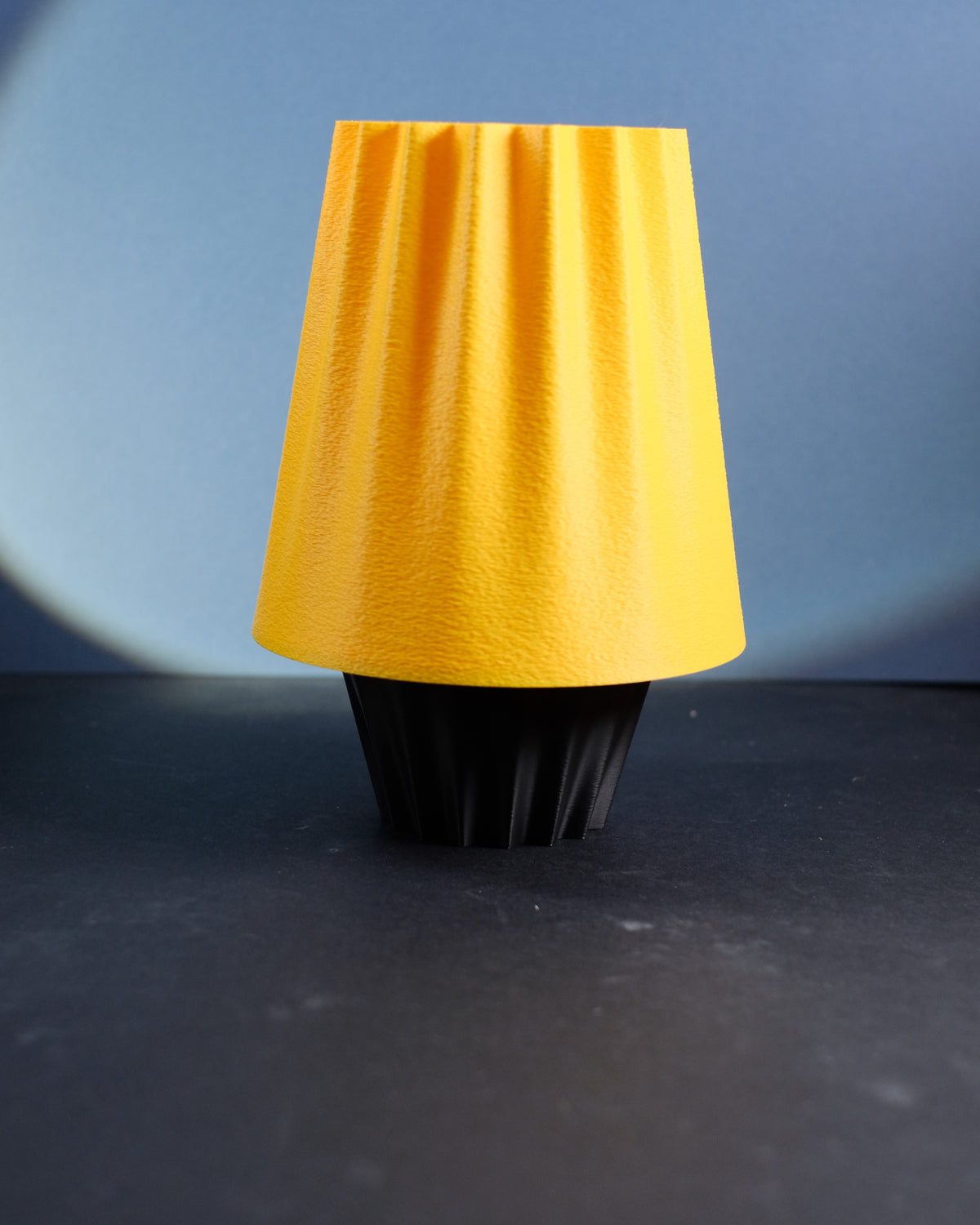 Fluted Ambient Desk Lamp with a glowing green fluted shade on a white surface