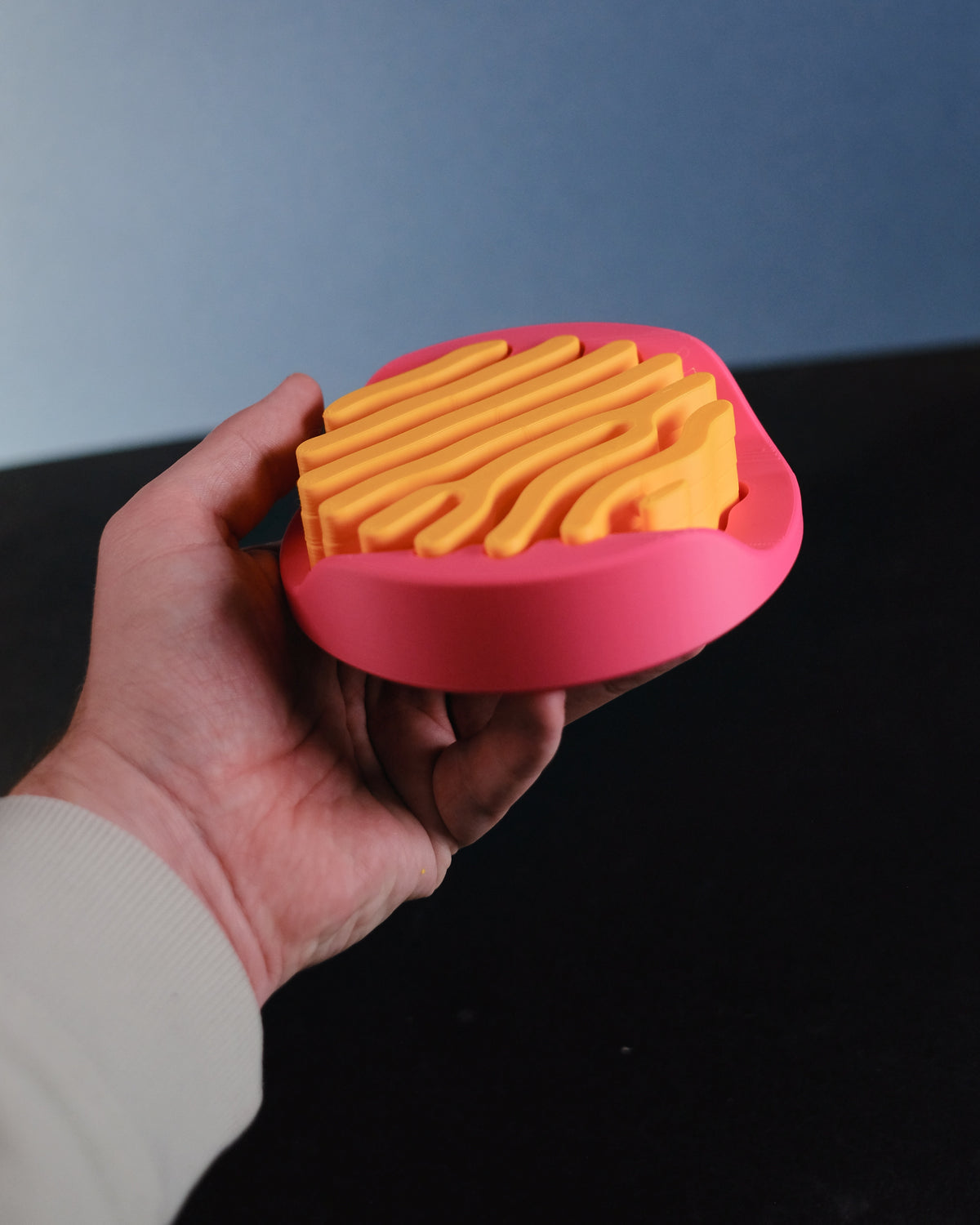 Individual orange branching coaster held in hand