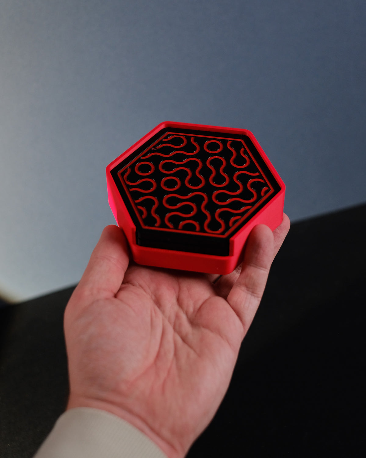 Hexagonal Truchet coaster holder on dark tabletop