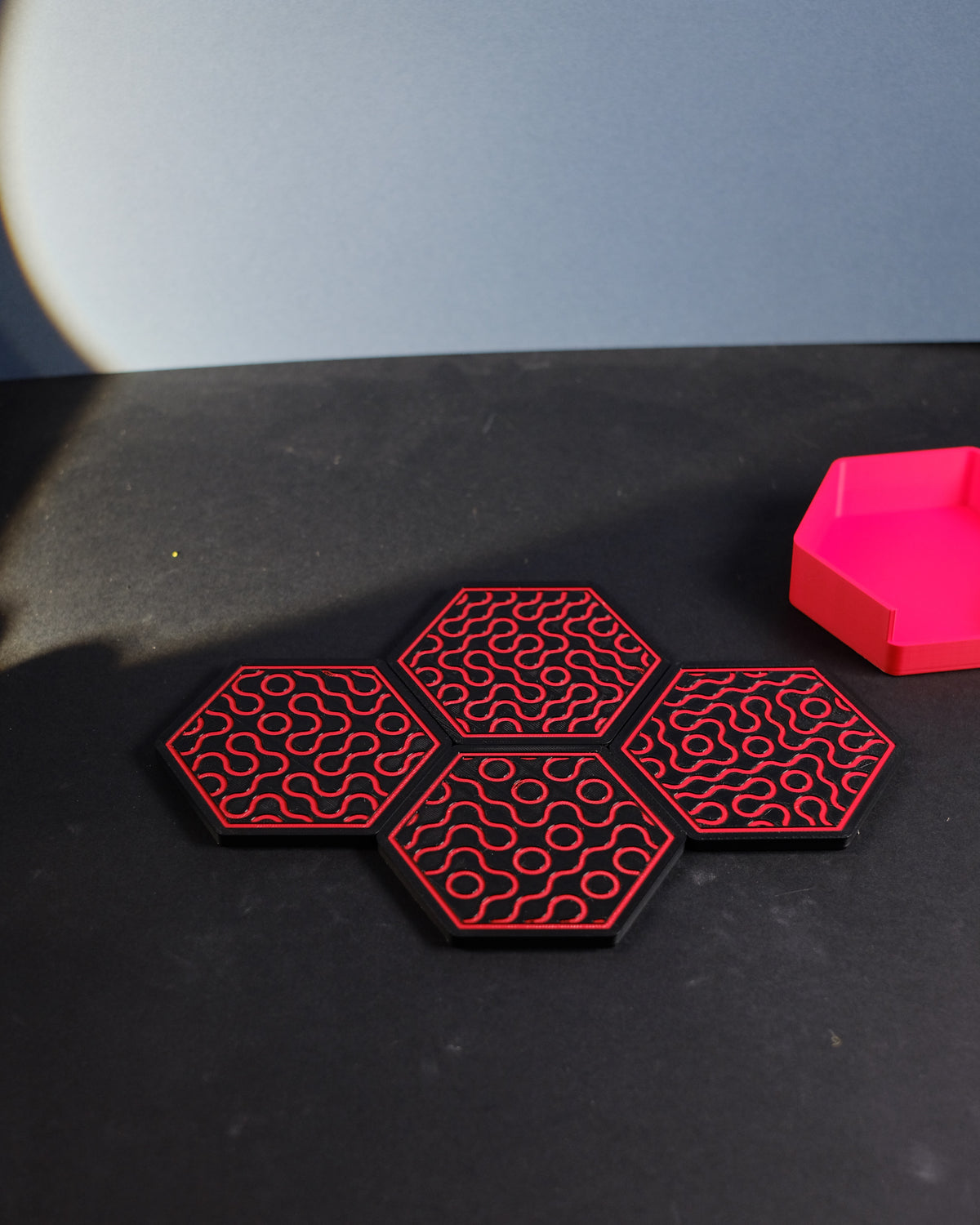 Four Truchet coasters nested in pink hexagonal holder