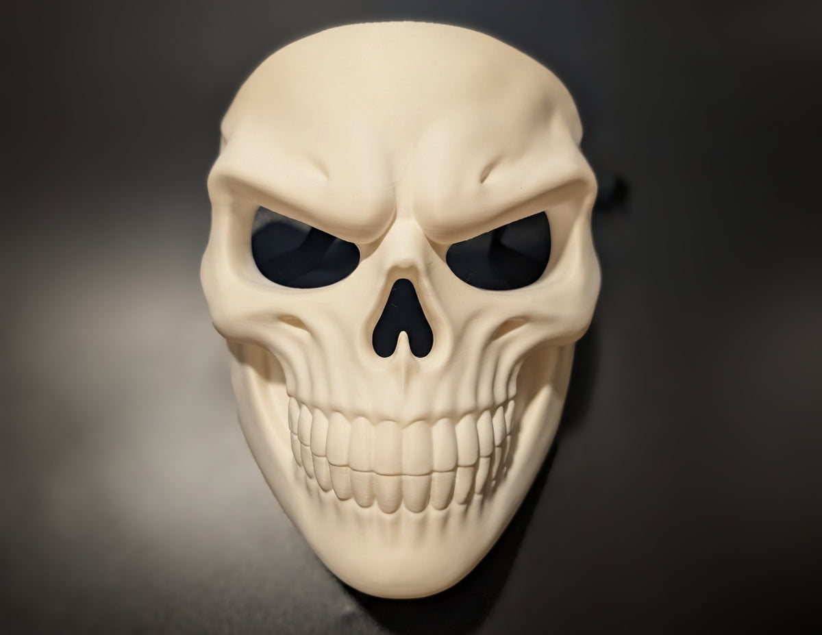 Front view of the Grinning Skull Mask showing its eye openings, nose shape and wide sculpted grin.