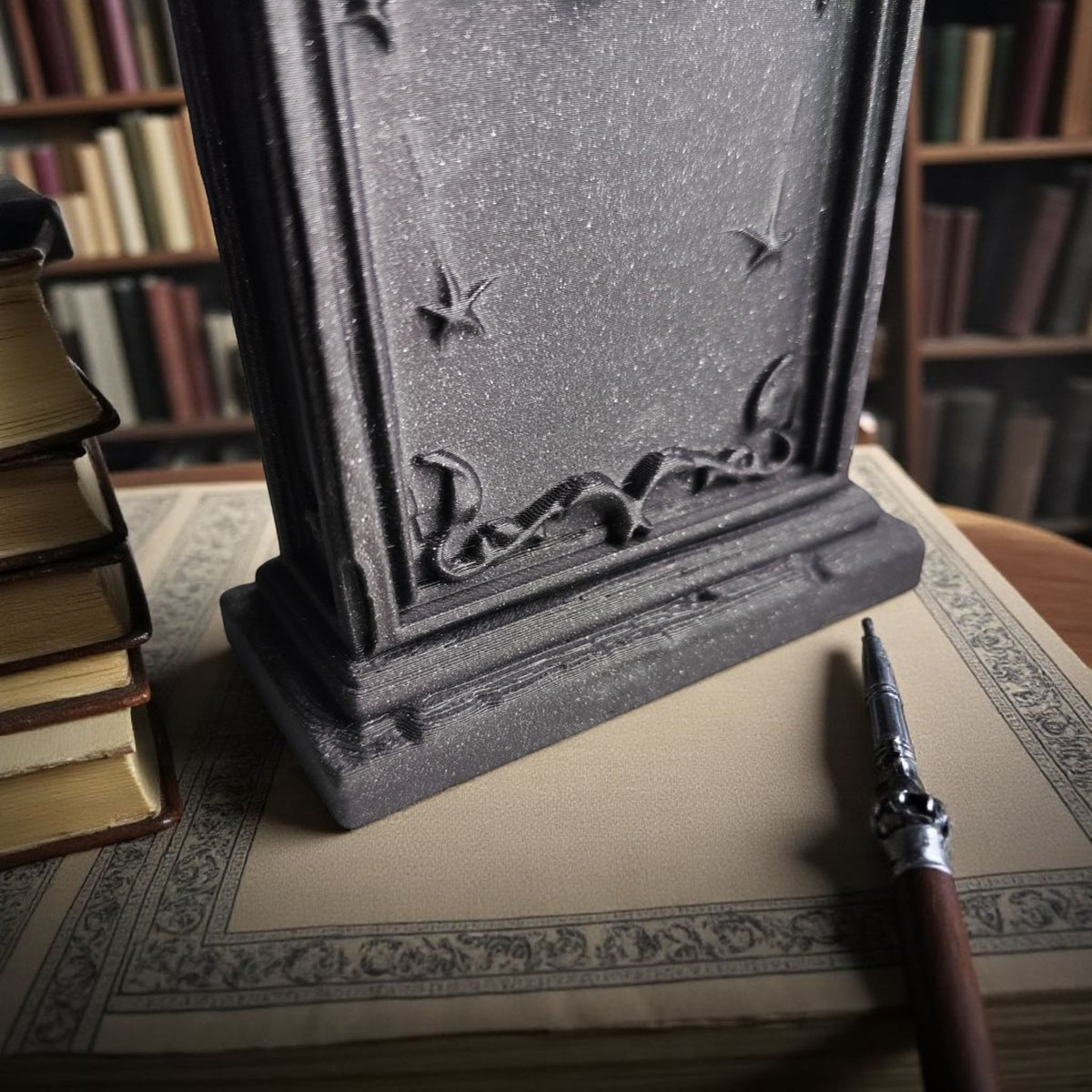 Grey gothic tombstone ornament on stacked antique books library lifestyle
