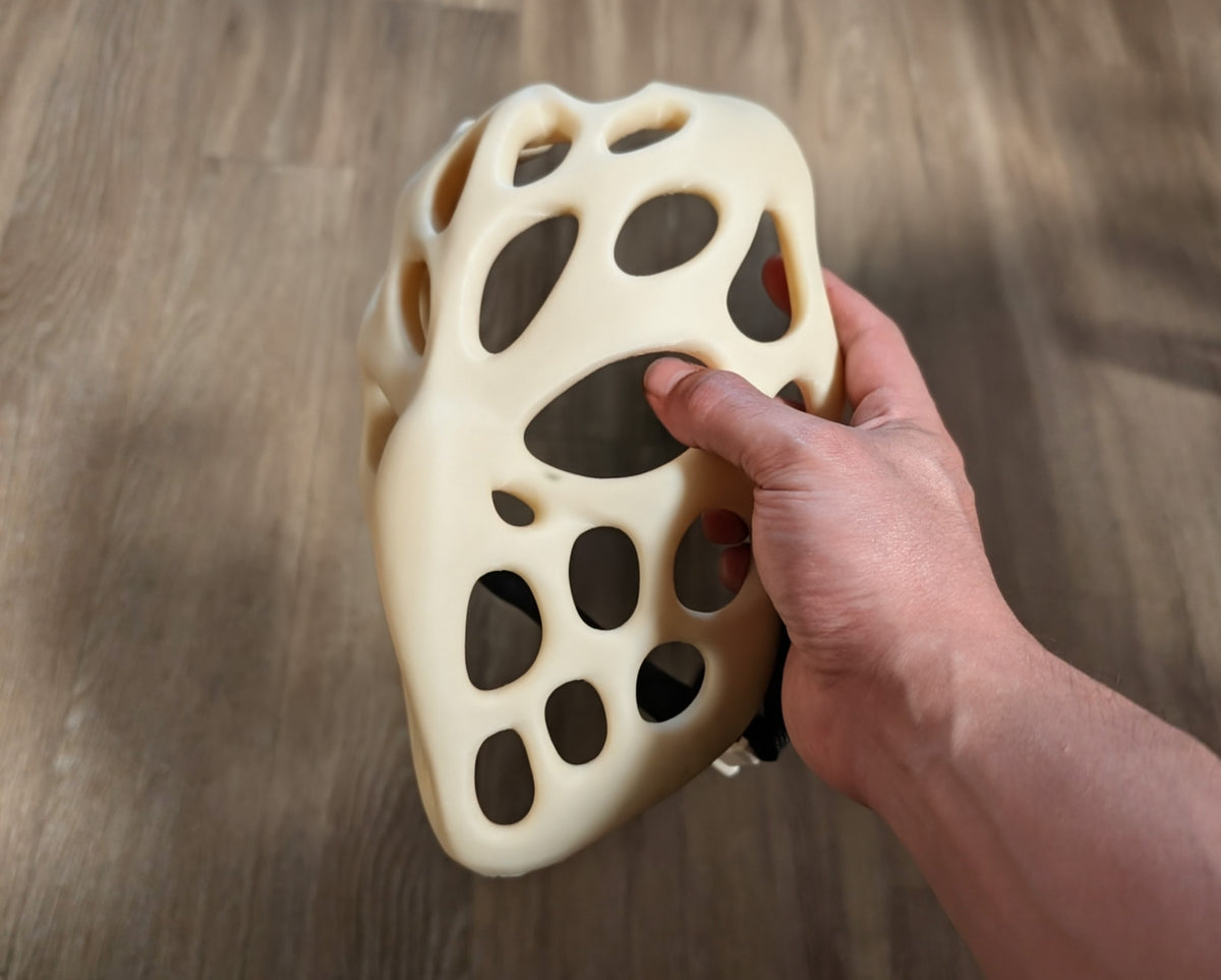 Ivory organic Voronoi Mask held close to show its flowing open cutouts; strap not included