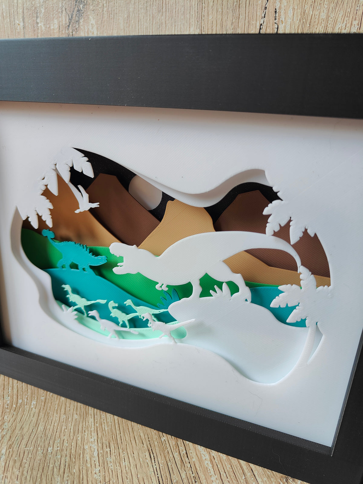 Dinosaur shadow box - close up angle showing T-Rex and raptor detail with teal and green layers