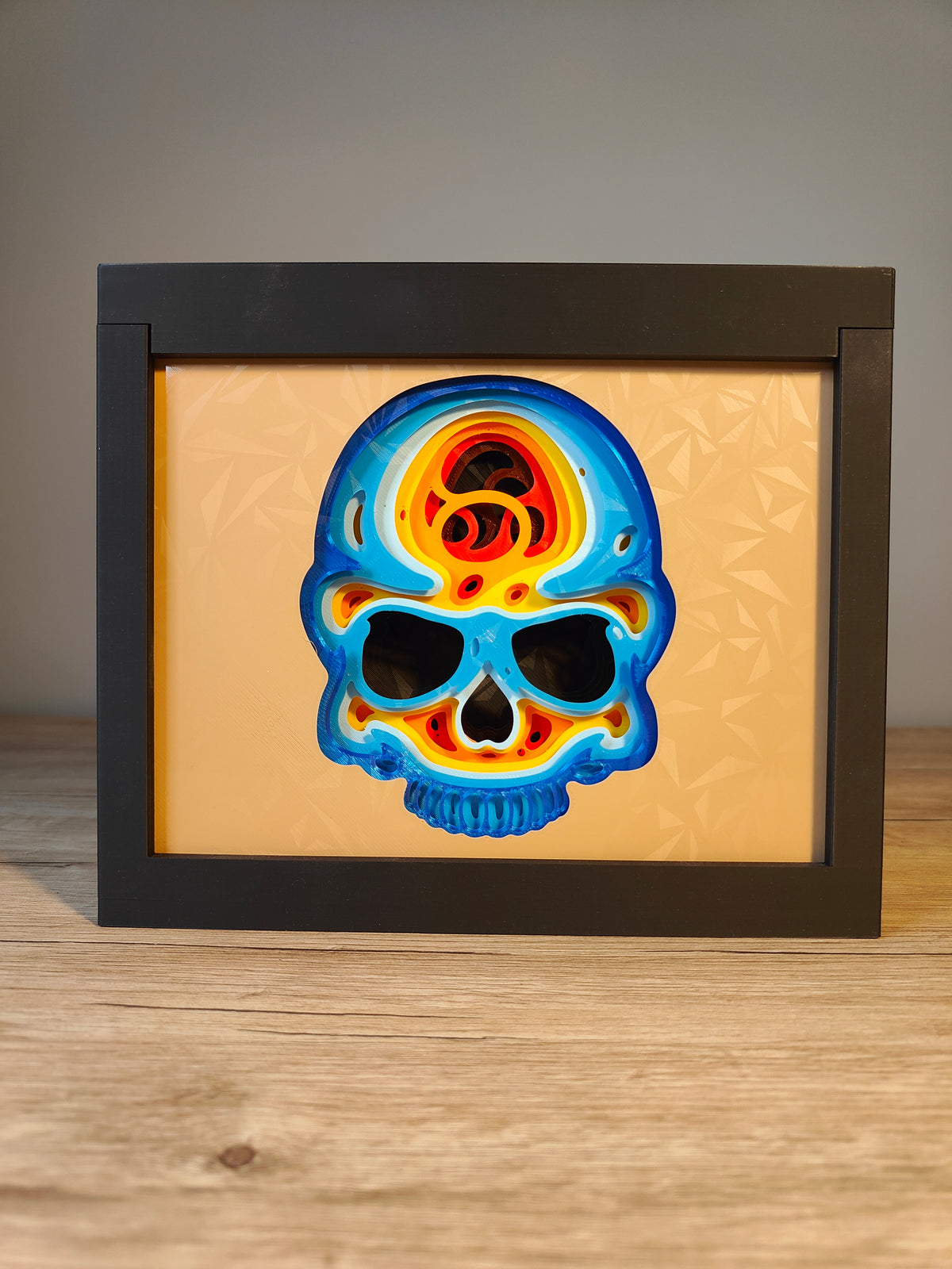Skull shadow box - front view with vivid blue yellow orange and red gradient