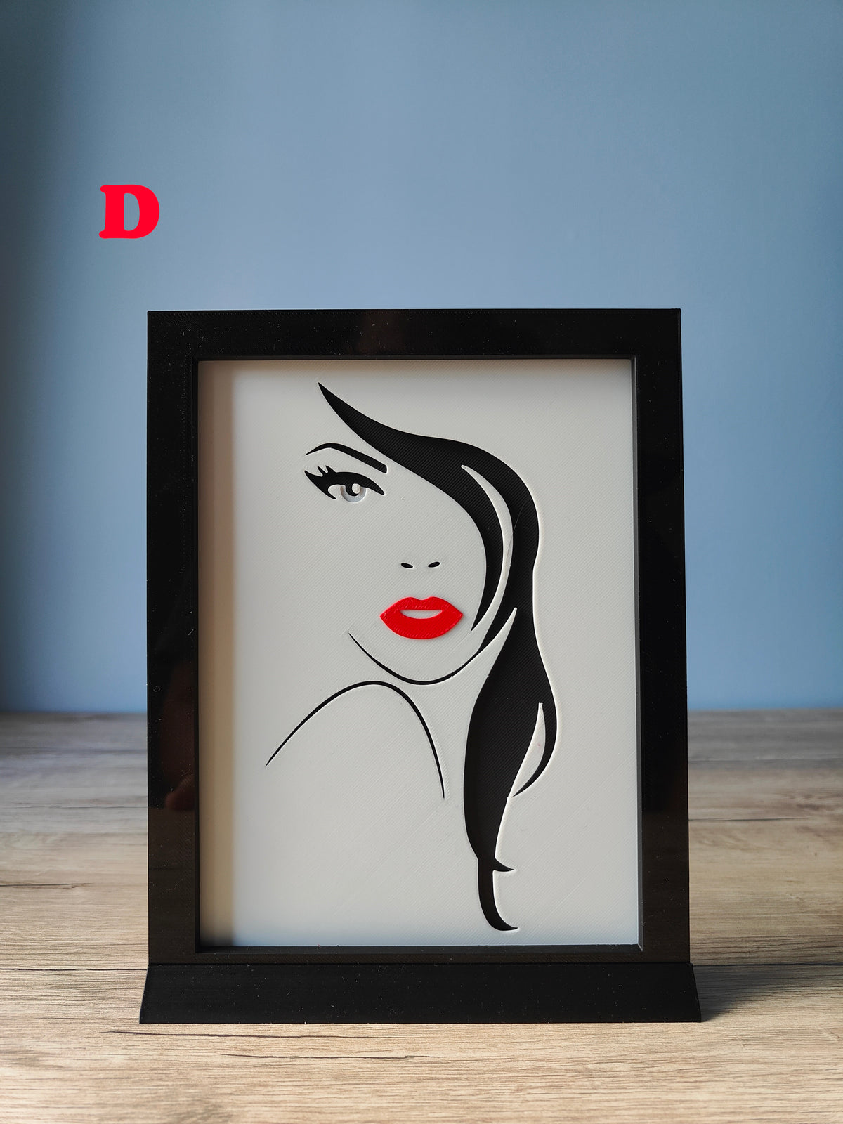 A Woman's Face Shadow Box G - bold front-facing portrait with flowing black hair and red lips