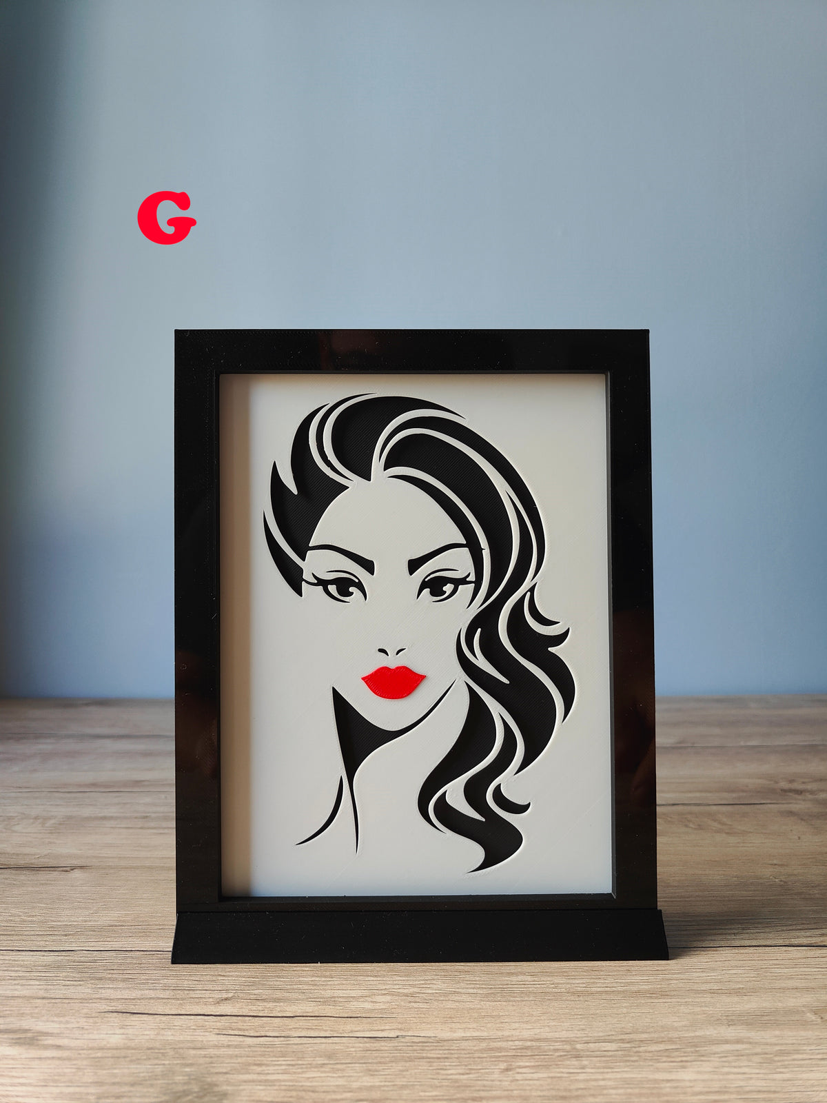 A Woman's Face Shadow Box F - serene upward-gazing face with sharp black hair and red lips
