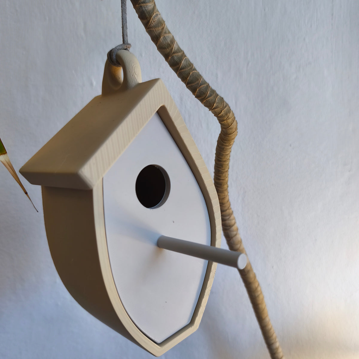 Angled view of pale birdhouse on a table