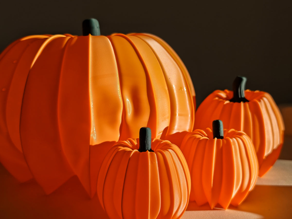 Three glowing orange pumpkins on tabletop