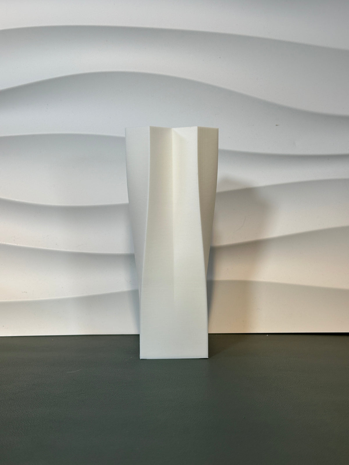 Quad Flow Vase pink four interlocked twisted square columns held in one hand close up dark background scale reference